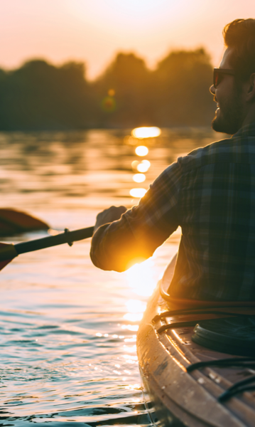 Full color view of man paddling boat on a lake