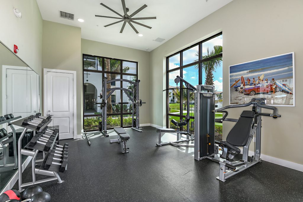 Indoor gym area with workout machines, weights, and floor to ceiling windows