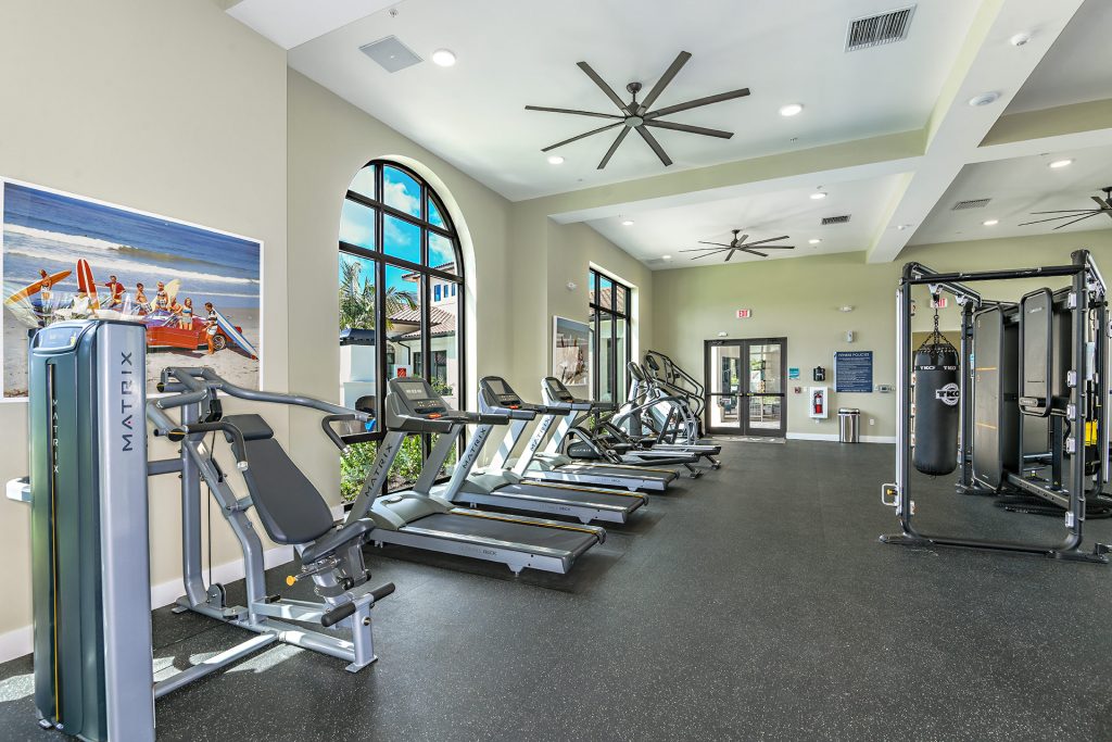 Indoor gym area with workout machines, punching bags, and floor to ceiling windows