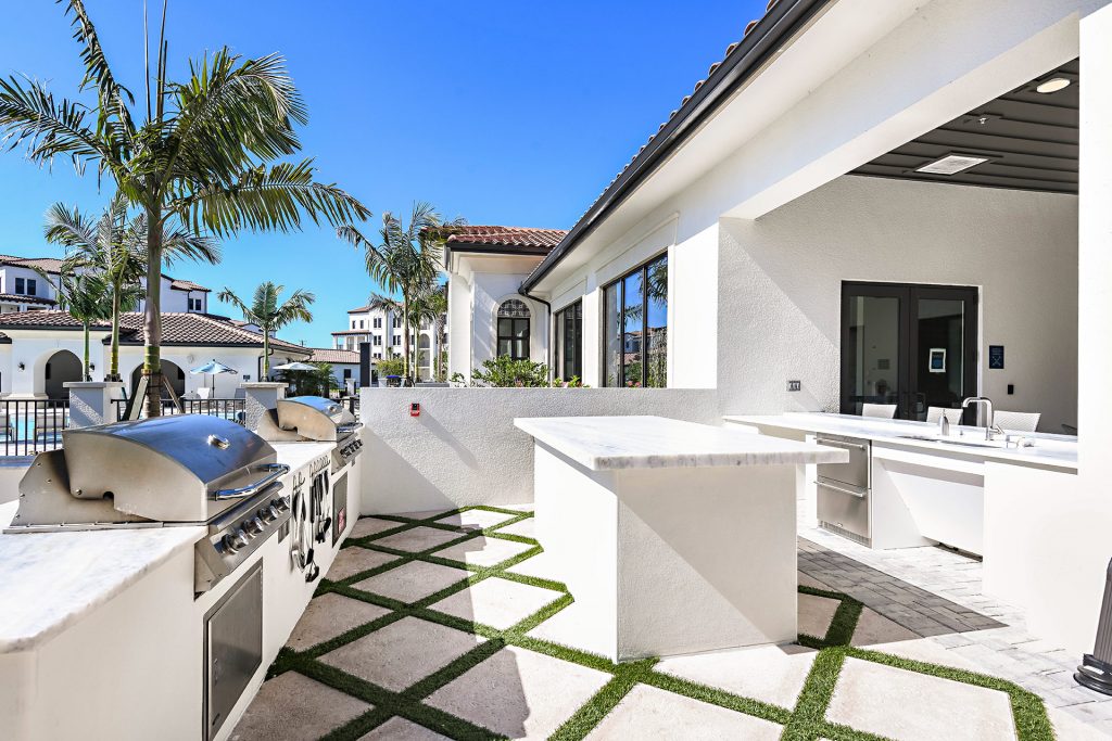 Outside deck with tropical landscaping, grills for cooking, and single sink