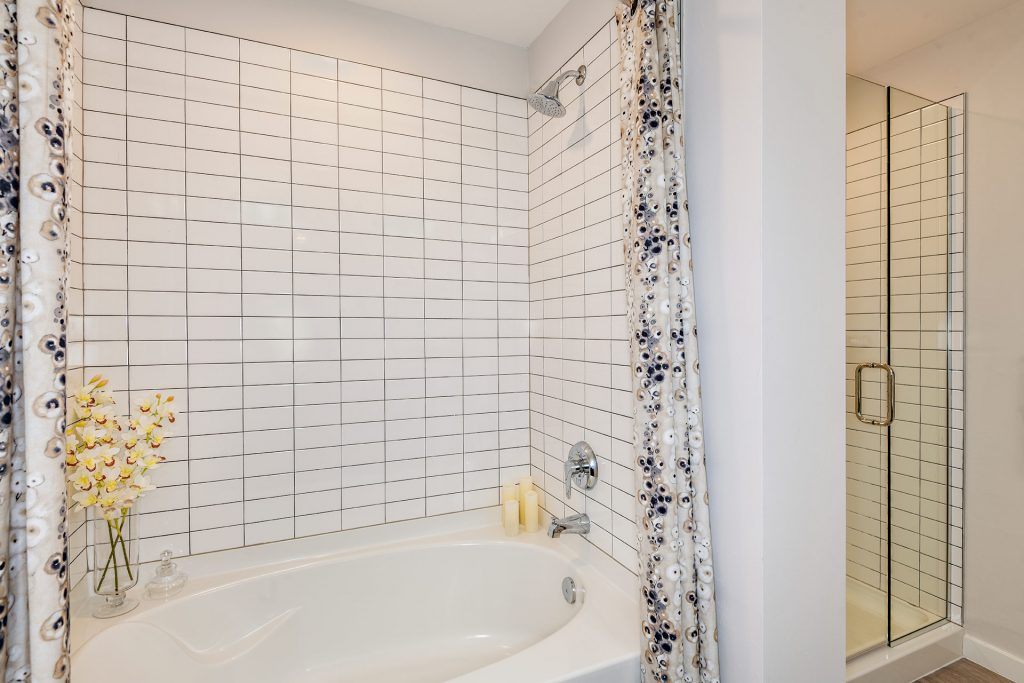 Bathroom with standup shower, bathtub and wood flooring