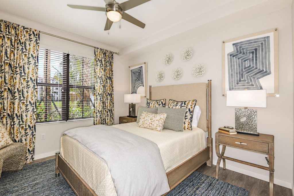 Bedroom with hardwood-style floors, wall paintings, and ceiling fans