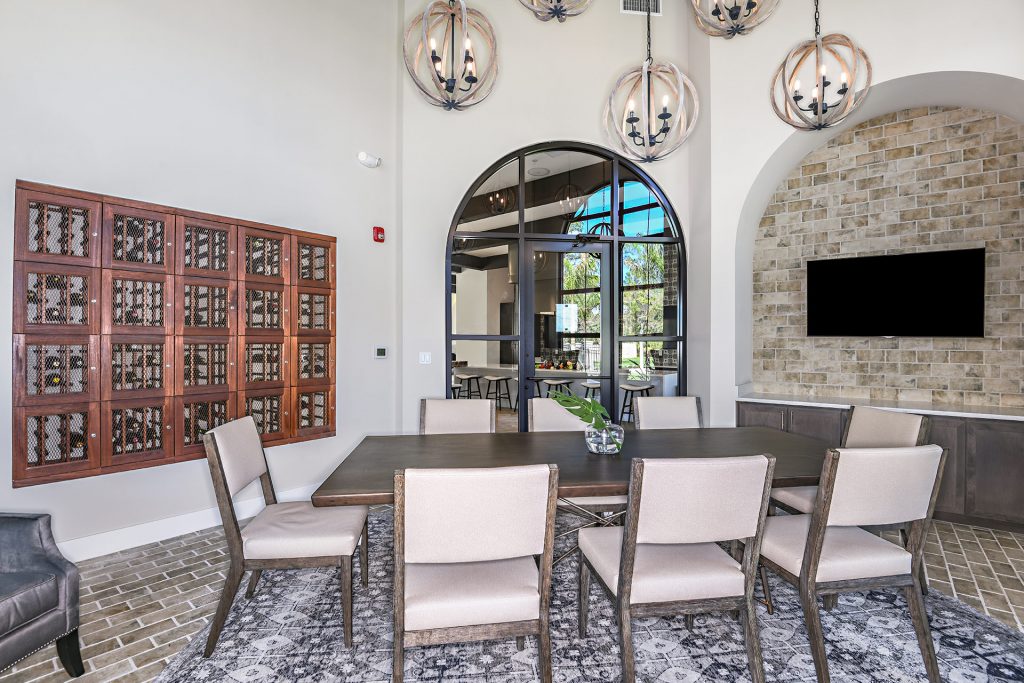 Wine room with table seating, television, and wine in stock